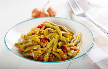Turkish Green Beans (Fasoulia) in dish on white background.
