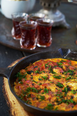 Shakshuka breakfast with fried egg and tomato in a pan