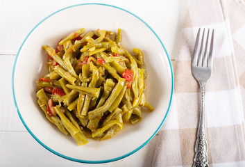 Turkish Green Beans (Fasoulia) in dish on white background.