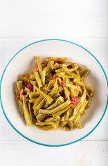 Turkish Green Beans (Fasoulia) in dish on white background.