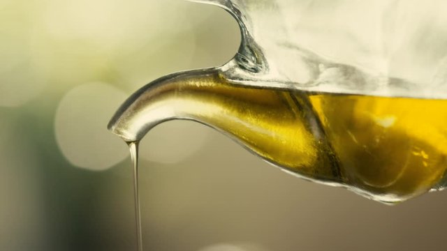 Pouring olive oil from glass bottle