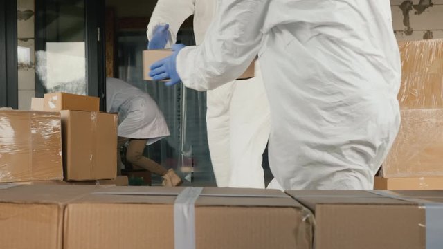 Carriers in antiviral suits unload boxes of medicines