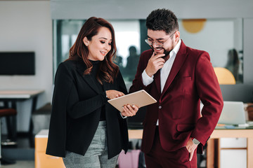 Latin business couple with arms crossed at the office in Mexico