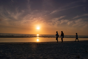 Fototapeta premium couple walking on the beach at sunset