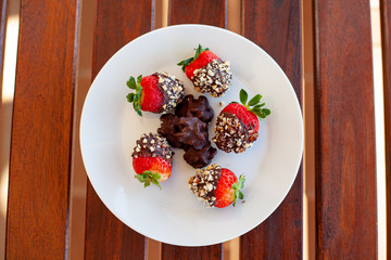 Breakfast bowl with quinoa, banana, coconut, cocoa, walnuts served on wooden table