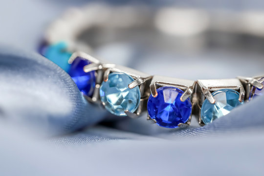 Close up shot of blue stone bracelet on Satin cloth