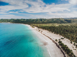 Aerial drone view of paradise beach with palm trees and blue water at the Esmeralda beach, Miches,...