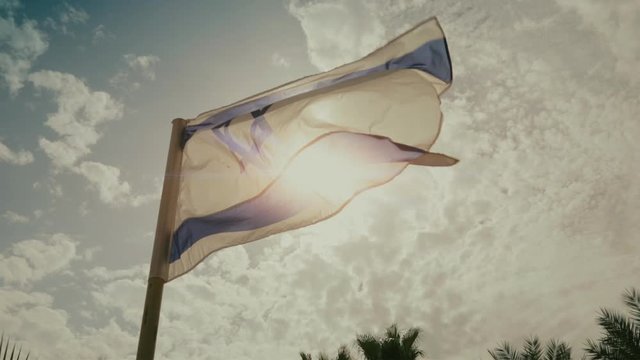 Flag of Israel blowing in the wind against sunlight
