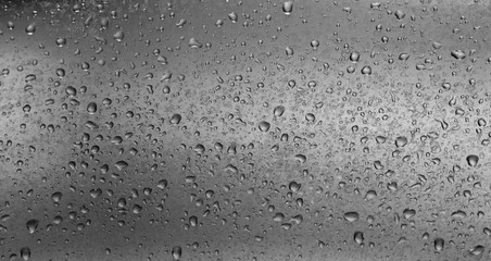 drops of water on grey surface in black and white