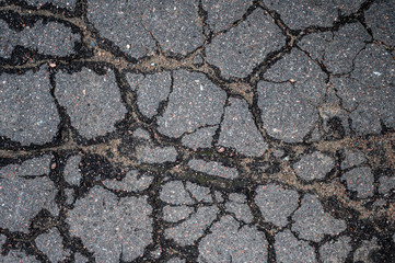 Road is very bad and old. Texture of worn and cracked asphalt with cracks.