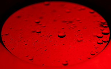 Abstract bubbles in liquid with red background. Different sized and shaped bubbles.