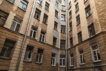 The courtyard of an old apartment building in St. Petersburg with yellow shabby walls