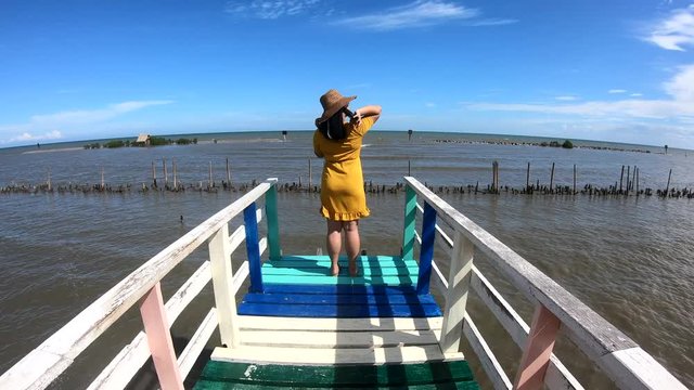 Pretty chubby asian woman standing relax on colorful rainbow bridge.