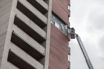 Russian rescuer examines the site of the collapse of the wall on a truck crane