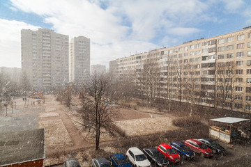 The courtyard of an apartment building in a residential area during a snowfall