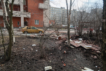 A pile of broken bricks and a destroyed car at the site of the collapse of the wall of a residential building