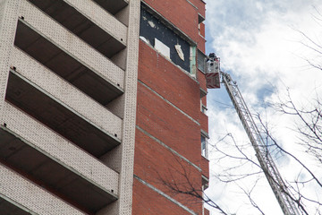Russian rescuer examines the site of the collapse of the wall on a truck crane