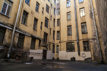 The courtyard of an old apartment building in St. Petersburg with yellow shabby walls