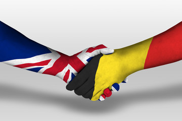 Handshake between belgium and united kingdom flags painted on hands, illustration with clipping path.