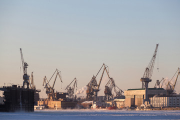 Fototapeta na wymiar Large industrial cranes of the admiralty shipyards in saint petersburg in winter
