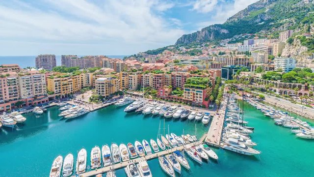 4K timelapse / hyperlapse of the cityscape and harbor of Monte Carlo or Port de Fontvieille, Monaco, Principality of Monaco in a cloudy and sunny summer day