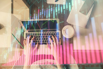 Double exposure of woman hands working on computer and forex chart hologram drawing. Top View. Financial analysis concept.