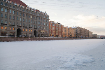 Fototapeta na wymiar Winter cityscape of St. Petersburg with the freezing Fontanka river