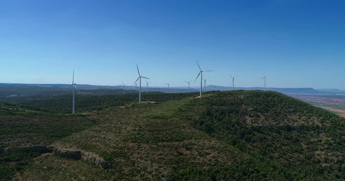 Aerial view of Wind Generating stations at big first mountains on a background of blue sky. Spain