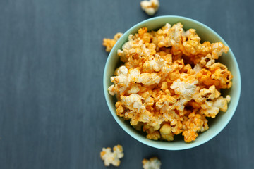 Delicious popcorn in a blue dish on a gray background. Selective focus. Space for text. Copy space
