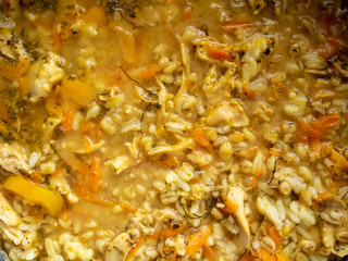 Various grains , chicken, and vegetables in homemade soup closeup