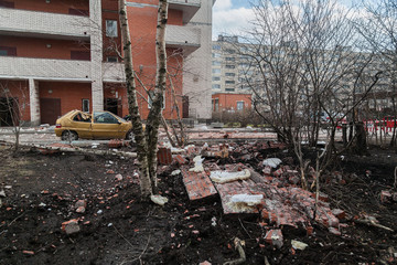 A pile of broken bricks and a destroyed car at the site of the collapse of the wall of a...