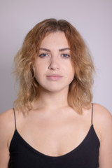 Fototapeta premium emotional portrait of a beautiful curly blonde-redhead in black undershirt. High quality photo