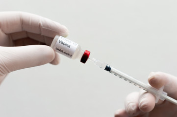 hands of the doctor filling a syringe with covid vaccine