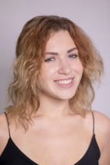 Naklejka premium emotional portrait of a beautiful curly blonde-redhead in black undershirt. High quality photo