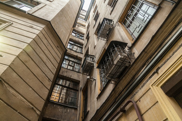 Obraz premium The courtyard of an old apartment building in St. Petersburg with yellow shabby walls