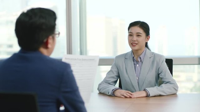 young asian college graduate business woman being interviewed by HR manager in modern corporation