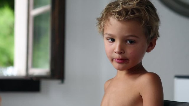 Toddler boy at breakfast table spitting food