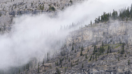 Detail of the rocky mountain with mist rolling in. Shot in Canadian Rockies on Kananaskis Ice Cave Trail, Alberta, Canada