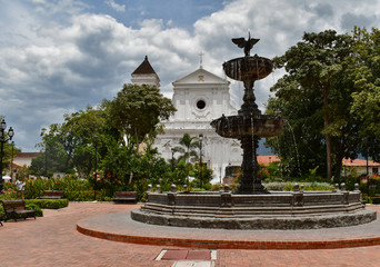 Naklejka premium Fuente e iglesia en parque principal de Santa Fe de Antioquia