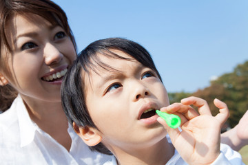 シャボン玉で遊ぶ母子