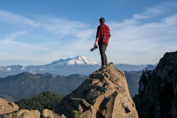 Young Man Stand On Top Of Cliff With Camera In The Pacific Northwest 