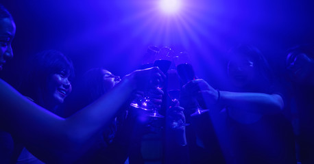 Fototapeta na wymiar friends enjoy party in nightclub and toasting wine together