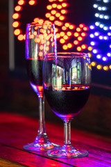 red wine glass against christmas lights decoration background, christmas atmosphere