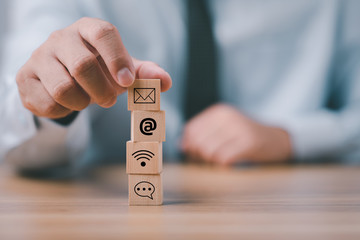 Businessman hand putting wooden block cube with icon Chat, email, address, wifi . Website page...