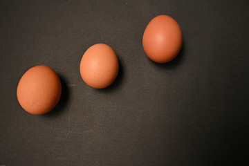 Three chicken eggs isolated on black background