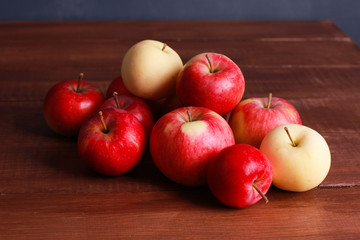 Heap of red and white apples on brown wooden table. Closeup view. Natural organic food, healthy eating, harvest season concept