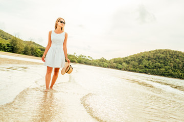 Woman in white dress on a tropical beach