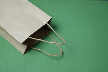 Shopping paper bag on green background.