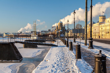 Winter cityscape of the Lieutenant Schmidt embankment in St. Petersburg with a sailboat in the winter parking lot and a view of the Assumption Church