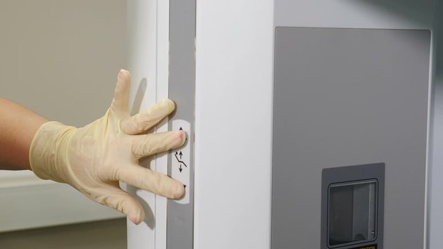 Healthcare concept. Unrecognizable doctor pushing button on mri machine in dental clinic to make panoramic x-ray or Mri scanning. Dental computer tomography. X-ray imaging. 4 k video